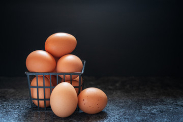 Fresh chicken brown eggs in a black plastic box on dark background