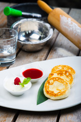 Traditional breakfast with coffee and cheesecakes, cottage cheese pancakes on a plate with syrup and jam.