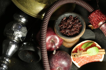 bowl with tobacco for hookah. fruits on a dark background. smoking nargile
