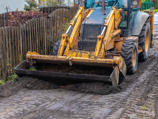 Fragment of the excavator. Repair work on the street of a residential quarter.