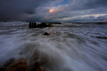 Sztorm na wybrzeżu Morza Bałtyckiego,wzburzone fale rozbijają się o kamienisty brzeg  . - obrazy, fototapety, plakaty