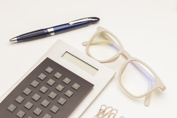 Calculadora, gafas y documentos; monedas de dinero y calculadora; calculando los beneficios de la empresa; preparando la declaración de impuestos