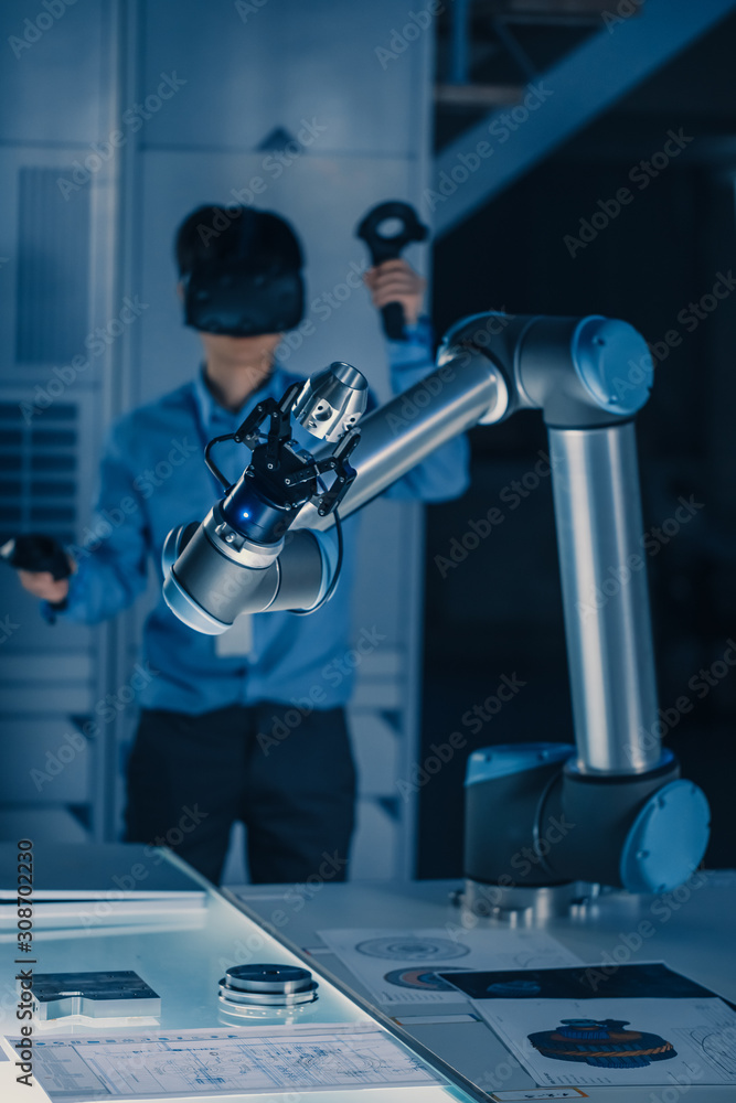 Poster vertical shot of professional development engineer in blue shirt controlling futuristic robotic arm 