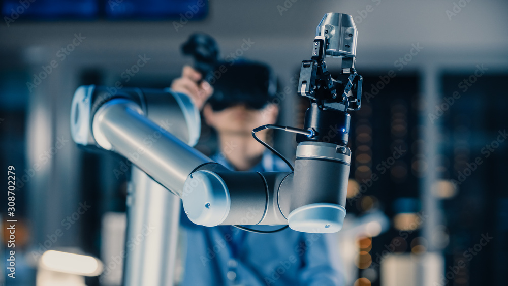 Fototapete close-up shot of a futuristic robotic arm controlled by professional development engineer with virtu