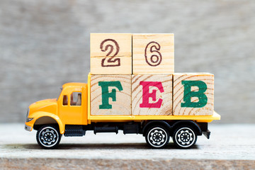 Truck hold letter block in word 26feb on wood background (Concept for date 26 month February)