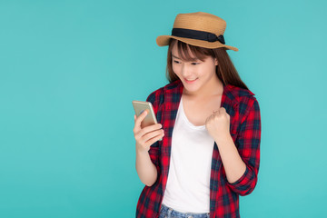 Beautiful young asian woman touch smart mobile phone in vacation isolated on blue background, asia girl excited and success talking or chat message on smartphone in travel summer trip concept.