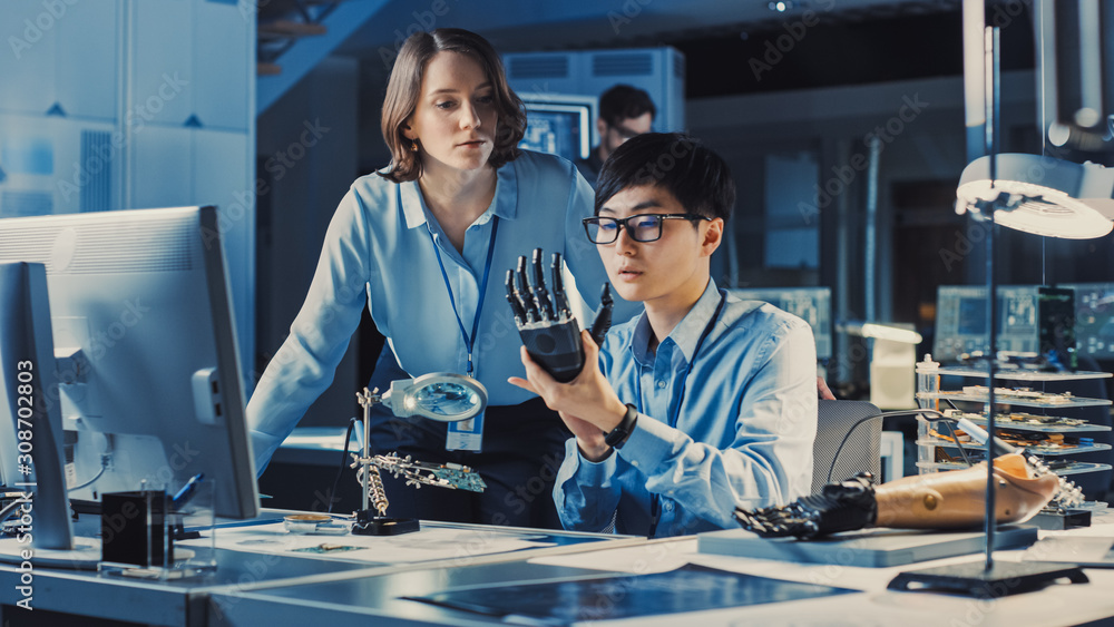 Aufkleber Technological Prosthetic Robot Arm is Closely Tested by Two Professional Specialists in a High Tech Research Laboratory with Modern Futuristic Equipment. Man and Female Talk and Ananlyse the Object.