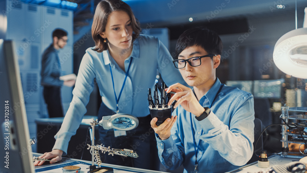 Leinwandbilder technological prosthetic robot arm is tested by two professional development engineers in high tech 