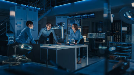 Futuristic Metal Robotic Arm is Moving a Metal Object. Senior Engineer Talks Through This Advanced...