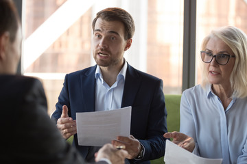 Angry businessman and mature businesswoman arguing with business partner