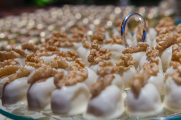 Detail of a  Dessert table with White chocolate and walnuts