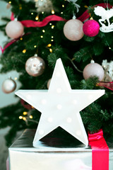 Big christmas star under the festive tree.