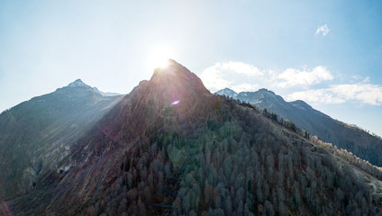 Aerial view of the Caucasus mountains in autumn in Krasnaya Polyana, Sun over the mountain. Russia.
