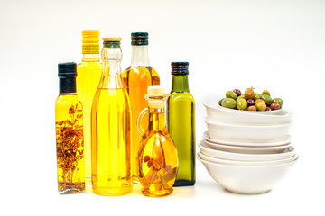 Various bottles with olive oil on a white background