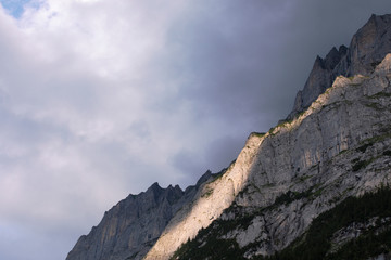 Close up of high mountain. Rocky landscape with band of light. Overcast background. Alps mountains, Switzerland.