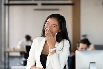 Head shot portrait of happy Asian businesswoman laughing at camera