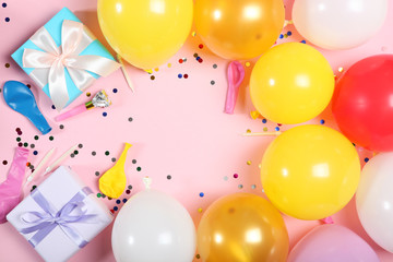 balloons and confetti on color top view. Festive background with place for text.