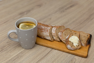 Tea with lemon, sliced bread with cheese and sandwiches