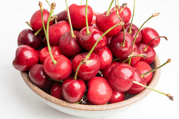 Fresh Red Cherries In A Small Round Stoneware Bowl