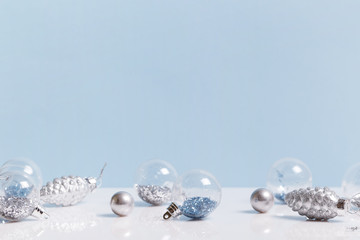 Christmas composition. Frame made of balls and snowflakes on pastel blue background.