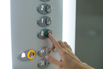 Woman's hand is pressing elevator button. Close-up Of Female's Hand Pressing Button In Elevator.