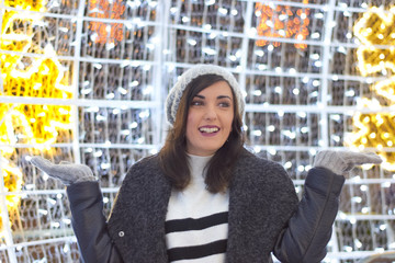 Fashion portrait of beautiful smiling brunette woman wearing a white wool sweater, a gray coat and...