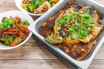 Sichuan Grilled Fish in red spicy oil, and mini lobsters. Authentic China, Chinese Szechuan Chongqing food on table.