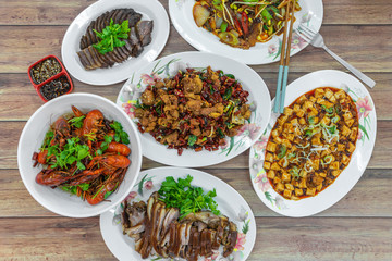 Flat lay top down view of table of authentic China Sichuan Hunan food. Assorted traditional dishes such as Fragrant Hotpot, crispy fried chicken, mini lobsters, spicy bean curd mapo doufu. - obrazy, fototapety, plakaty