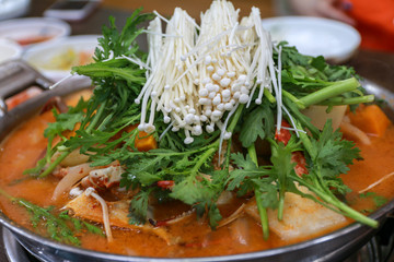 Korean traditional food spicy crab stew soup with enoki mushroom and vegetables on a big pot