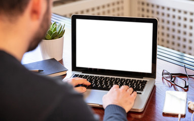 Laptop with white blank screen on a wooden desk