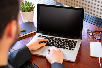 Laptop with black blank screen on a wooden desk