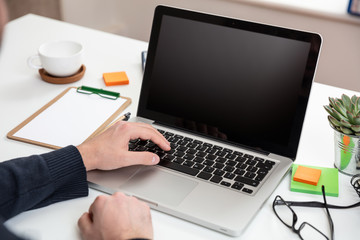 Laptop with black blank screen on a wooden desk