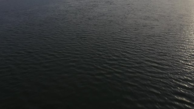 Aerial pan up reveal of Kemsley, Sittiingbourne industry from the Swale Estuary.