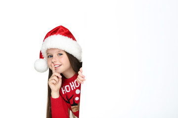 Little girl in christmas sweater and hat with blank board on white background