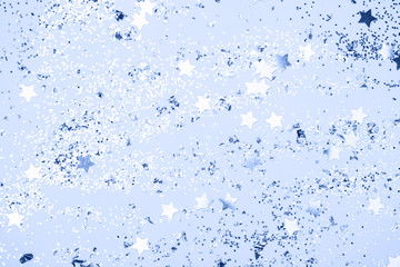 confetti and stars and sparkles on Classic Blue Christmas background. Top view, flat lay. Copyspace for text. Bright and festive holiday background. Color of year 2020.