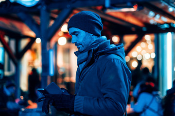 Fototapeta na wymiar man outdoor in the city using a mobile phone -stylish freelancer in the winter season