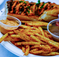 Spicy Fries with Beef Sandwich in Background with Au Jus and Remoulade