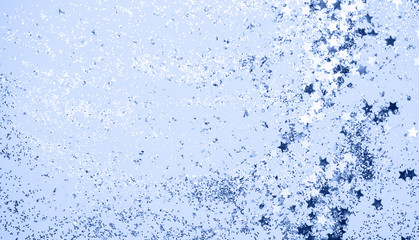 confetti and stars and sparkles on Classic Blue Christmas background. Top view, flat lay. Copyspace for text. Bright and festive holiday background. Color of year 2020.
