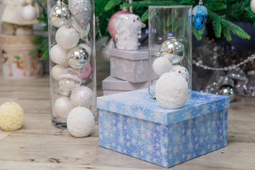 Beautiful new year balls, gray and blue boxes with Christmas gifts lie under the tree. The concept of preparing for the Christmas holidays and decorating the Christmas tree.