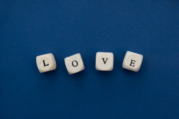 Love is love message written on wooden blocks over blue background.