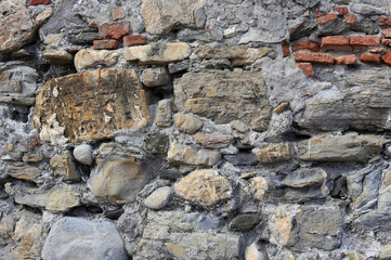 Very old wall from stones of various shapes and red bricks