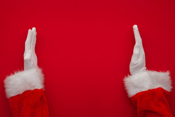 Santa Claus making frame with hand on red background with copy space