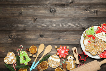 Christmas gingerbread cookies with kitchen utensils, candies and fir tree branches on brown wooden table