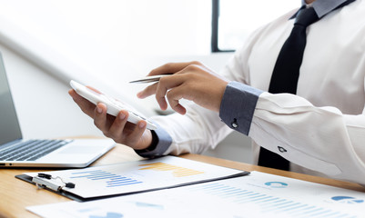 Business men use calculators to calculate the company's tax and revenue in the office, Financial and accounting banking concepts.