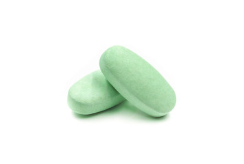 Close-up of green pills medicine, vitamin tablets isolated on white background.