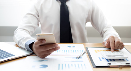 Fototapeta premium Business men use calculators to calculate the company's tax and revenue in the office, Financial and accounting banking concepts.