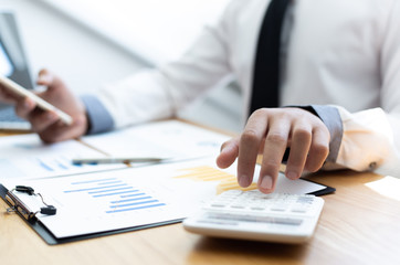 Business men use calculators to calculate the company's tax and revenue in the office, Financial and accounting banking concepts.