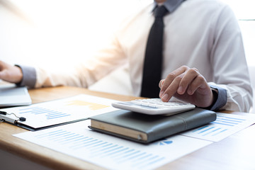 Business men use calculators to calculate the company's tax and revenue in the office, Financial and accounting banking concepts.