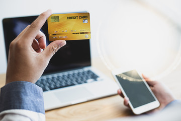 Men Hands holding credit card and using laptop. Online shopping Concept