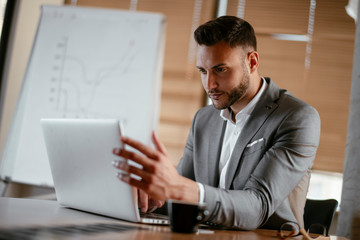 Obraz premium Handsome businessman in office. Successful man in suit working in office. 